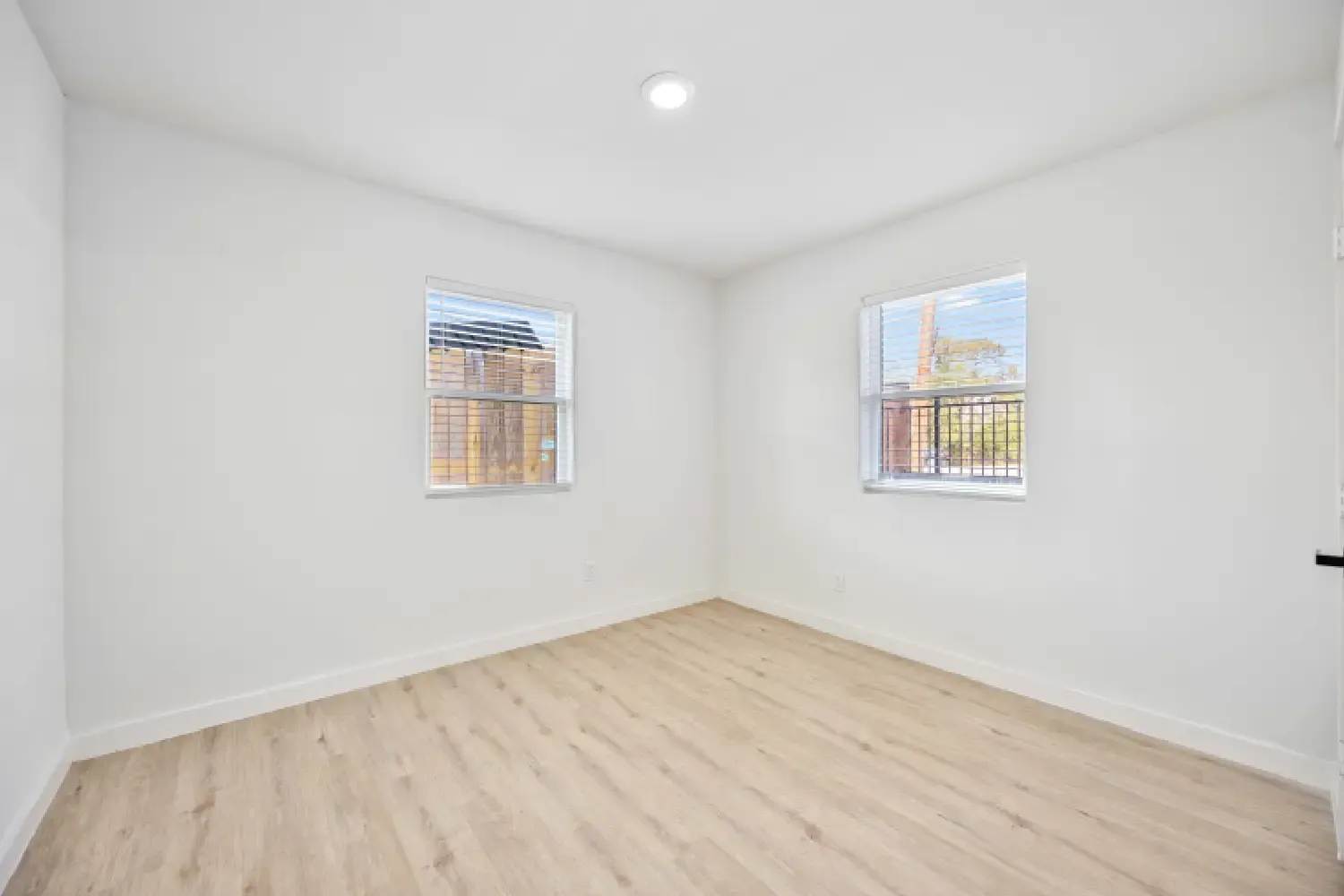 Bedroom with two windows and vinyl plank flooring